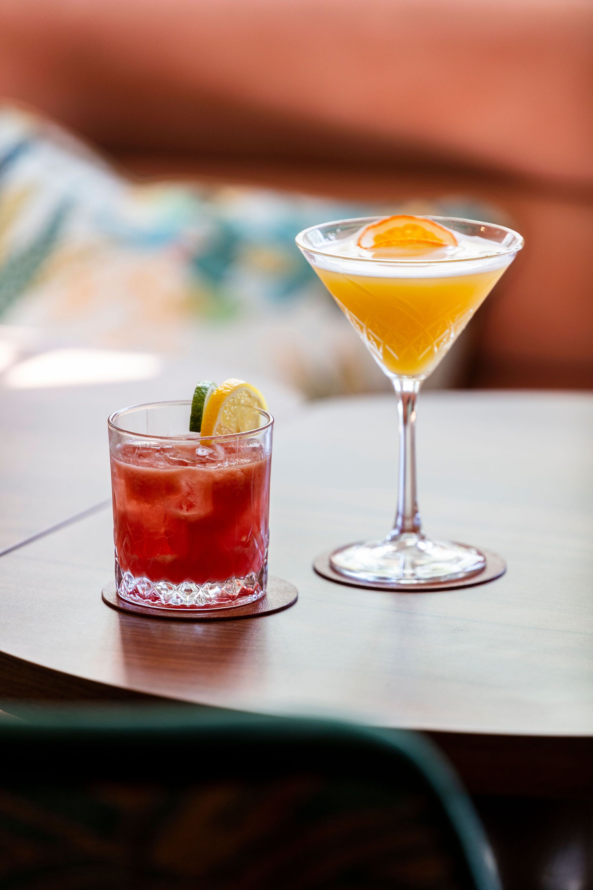 Two drinks on a table with a blurred background.