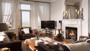 Ein Wohnzimmer mit Kamin, Fernseher und einem großen Spiegel.