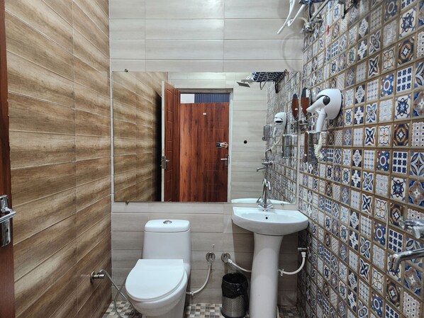 A bathroom with a toilet, sink, and a mirror.
