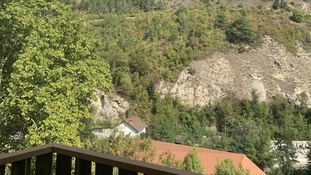 A mountain landscape with a house surrounded by trees and rocky terrain. - 200m from ski lifts, 7th floor, view mountain, balcony, tv, ski locker, 69m², Brides Les Bains (Brides-les-Bains)