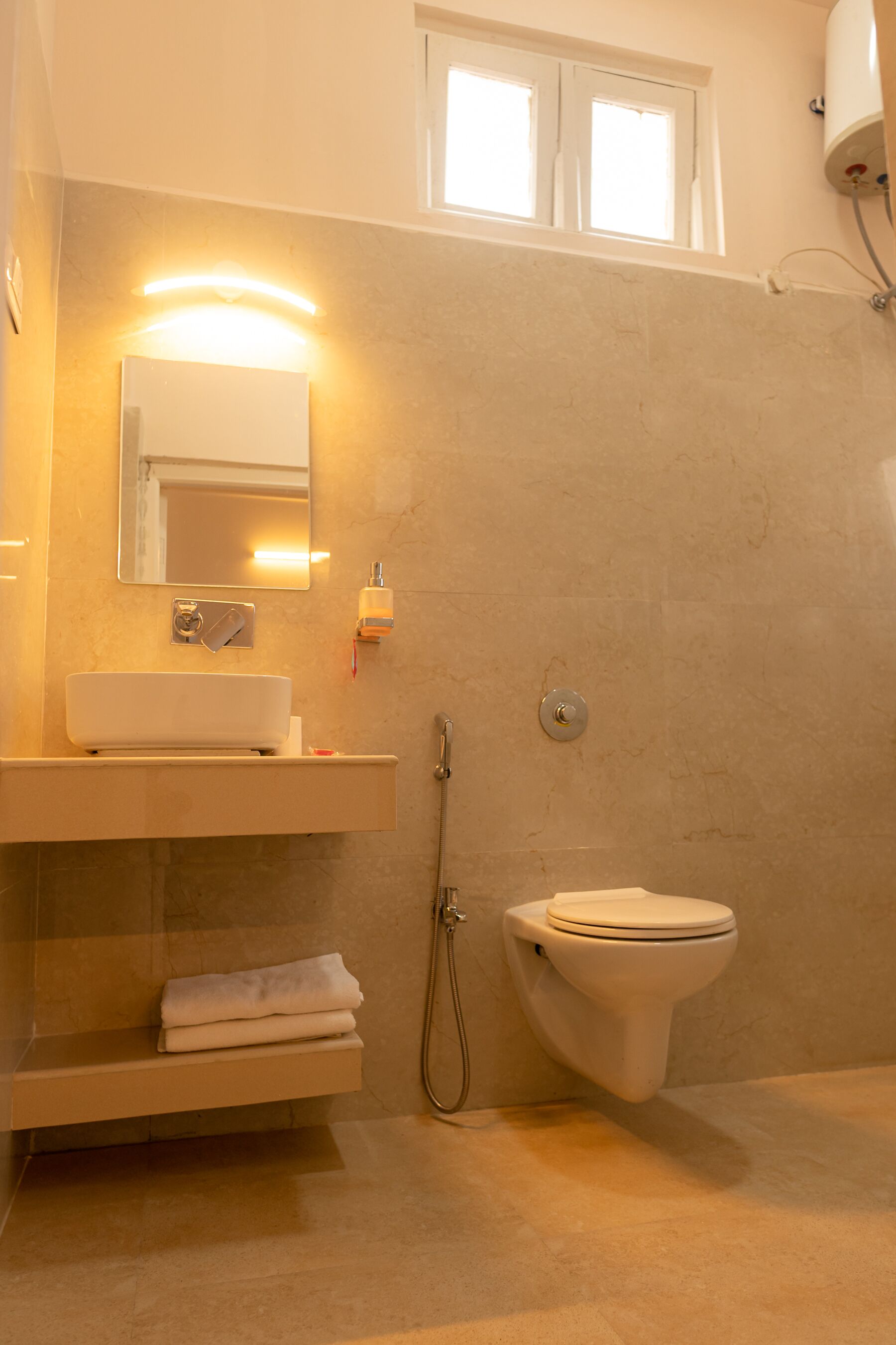 Un baño con lavabo, espejo, toallero, inodoro y ducha.