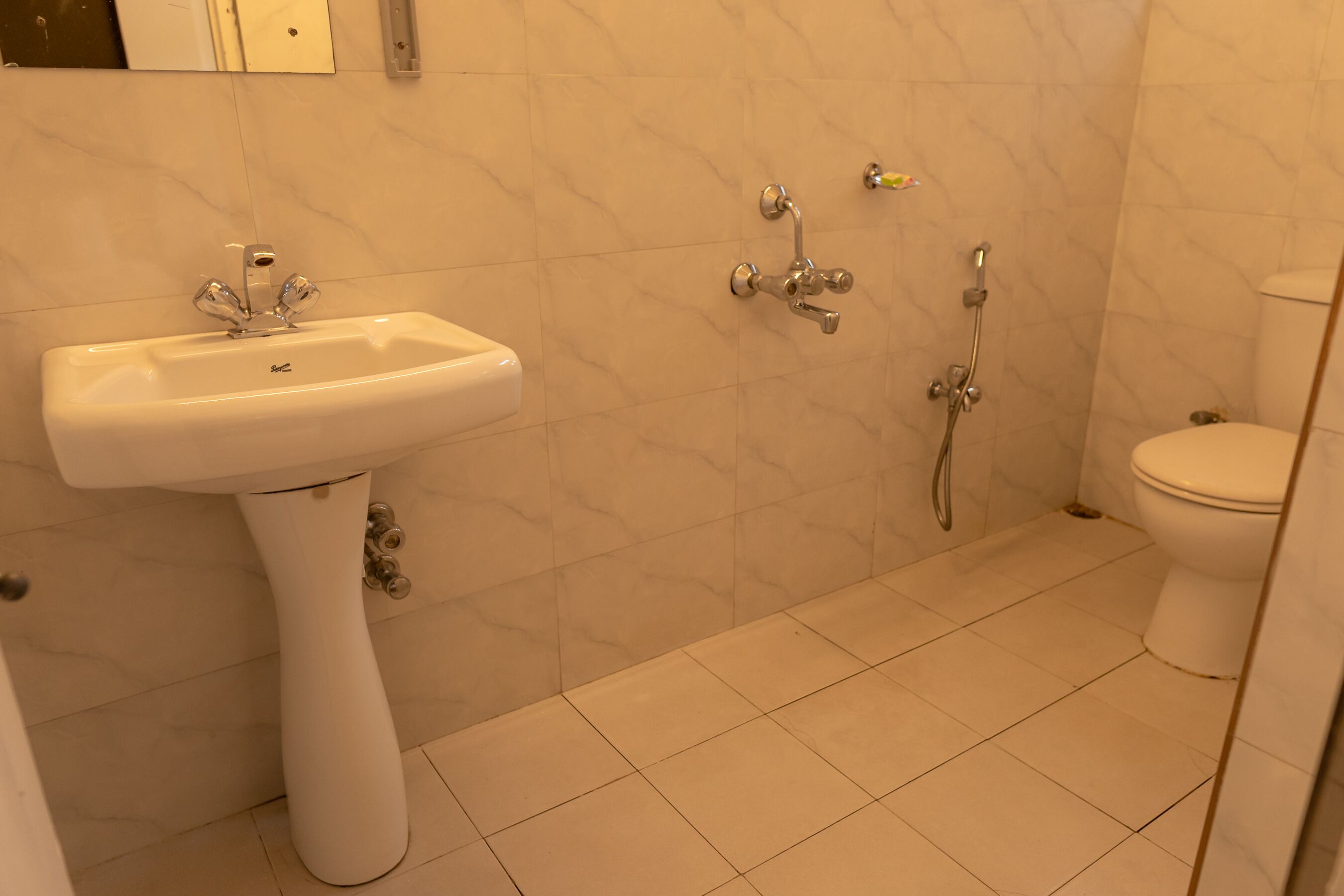 A bathroom with a white sink, a toilet, and a shower.