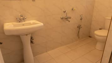 Un baño con lavamanos blanco, inodoro y ducha.