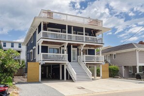 Un bâtiment à deux étages doté d’un balcon à l’étage supérieur, d’un porche avant couvert et d’un escalier menant à l’entrée.