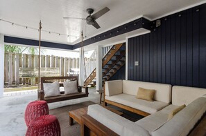 Un salon moderne avec un canapé, une balançoire et un escalier.