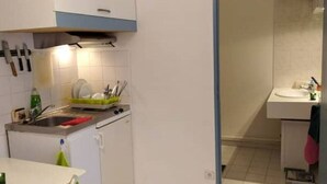 Una cucina compatta con lavello, fornelli e utensili.
