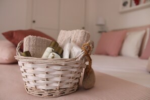 A wicker basket with toiletries on a bed with pink bedding. - Minicasa con ampio spazio verde attrezzato (massa lubrense)