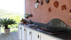 Uma cozinha com bancada de pedra, pia e painel de azulejos decorativos.
