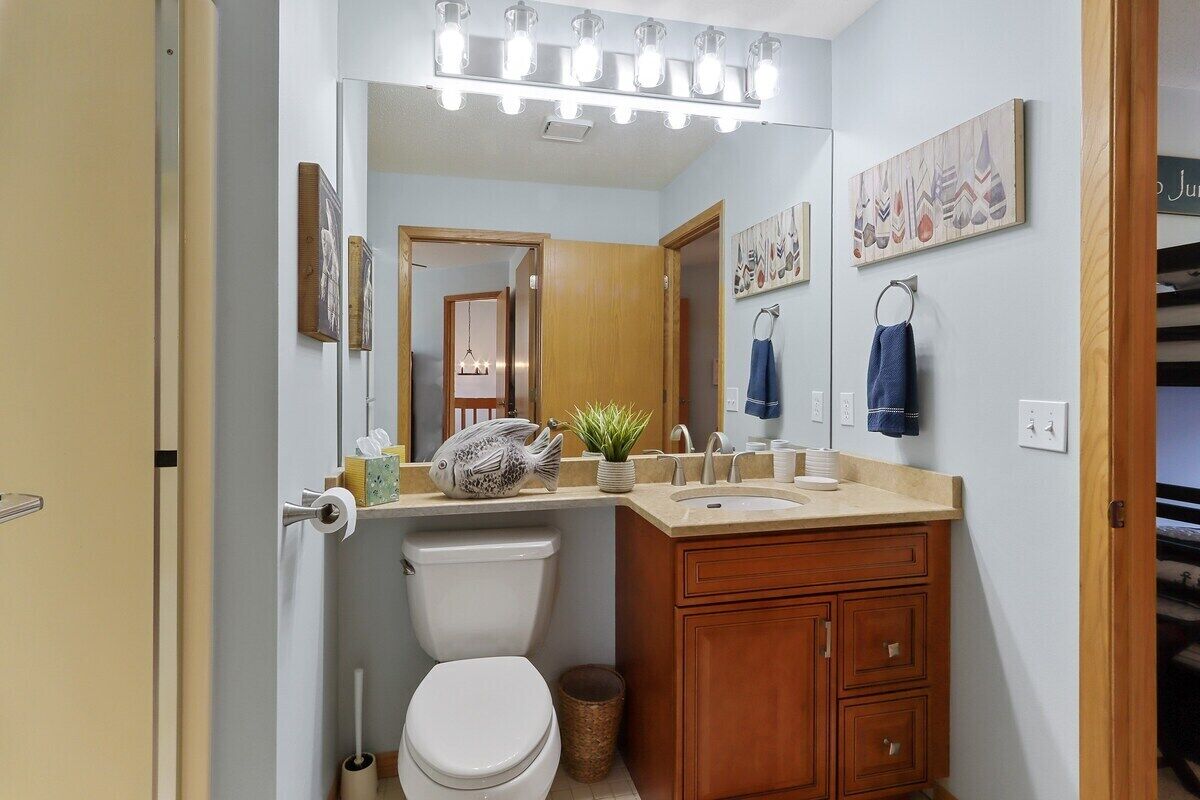 Ein Badezimmer mit Toilette, Waschbecken, Waschtisch und Spiegel.