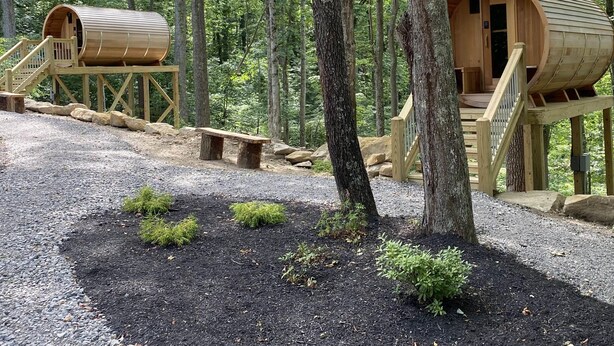 Two wooden cabins with wooden staircases and a gravel path between them. - Legends Lane A - Hosted by The Chalets (Logan)