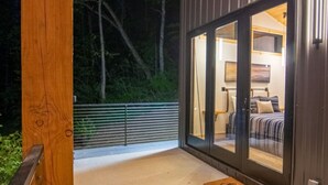 A modern, well-lit room with a large sliding glass door leading to a balcony. - Legends Lane A - Hosted by The Chalets (Logan)