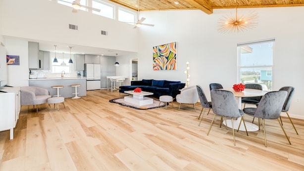 Un amplio espacio habitable con una cocina moderna, un comedor y un ventanal que proporciona luz natural.