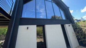 A modern house with a large glass window and a black roof. - Maison du Rocher Plat - Vue Mer - Proche Plage - 4 (Saint-Jacut-de-la-Mer)
