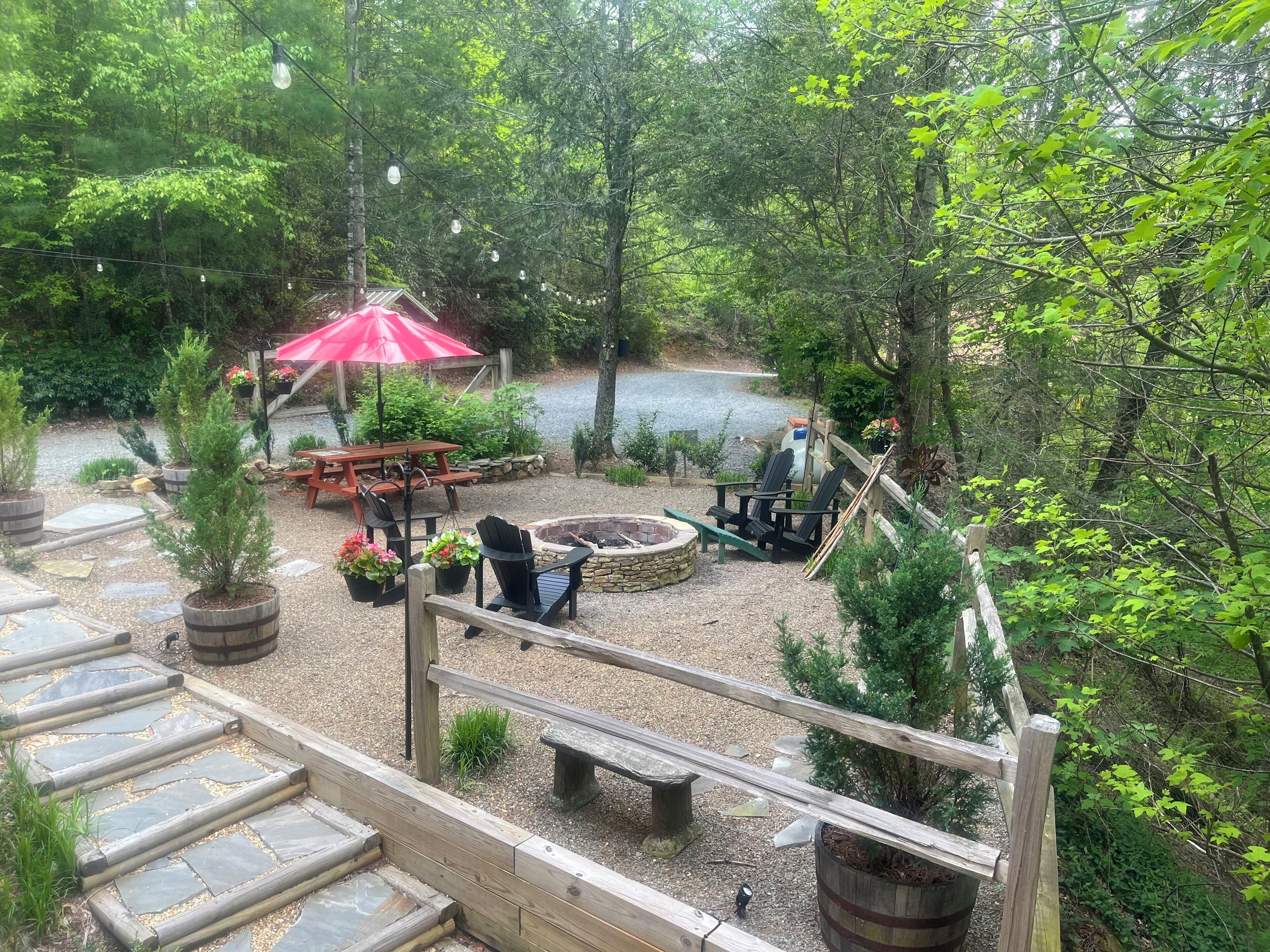 Un espace patio agrémenté d’un foyer en pierre, de sièges d’extérieur et d’une terrasse en bois.
