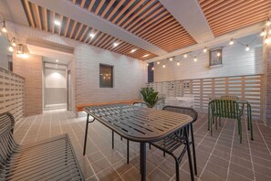 A modern interior with a long table, chairs, and a ceiling with wooden slats and string lights. - Hound Hotel Sungshin Women's University Branch (Seoul)