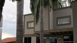 A modern building with a flat roof, large windows, and a red tactile paving path. - Cerrado Hotel (Campo Grande)
