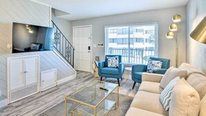 A modern living room with a staircase, a sofa, a chair, and a coffee table. - Airy Oceanfront Condo: Steps to Daytona Beach (Daytona Beach)