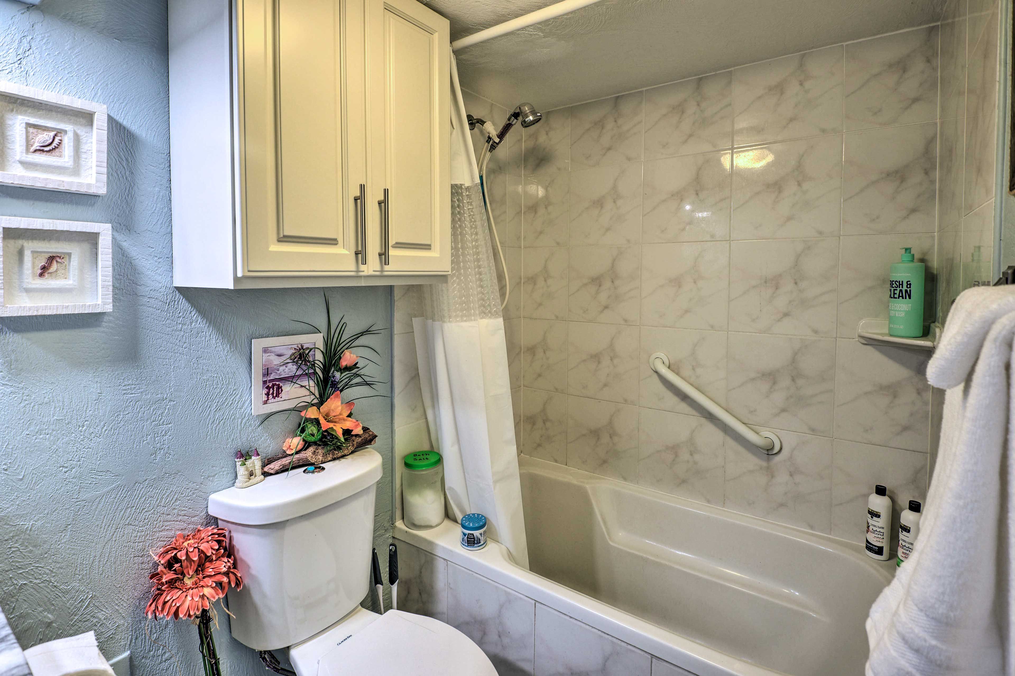 A bathroom with a shower, toilet, and a sink.