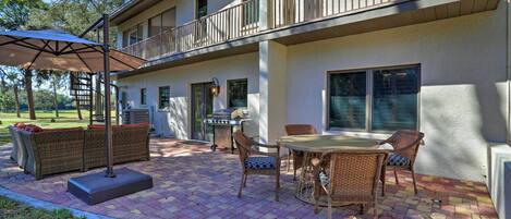 A patio with outdoor furniture, a grill, and a covered seating area.