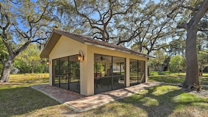 A small, single-story building with large windows and a covered patio area. - The Peacock Farm Largo Home + Outdoor Oasis! (Seminole)