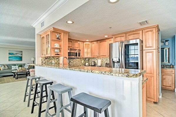 A spacious kitchen with a large island, wooden cabinets, and modern appliances.