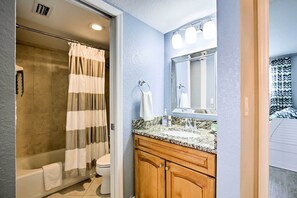 Une salle de bain équipée d’une douche, de toilettes et d’un meuble-lavabo avec un miroir.
