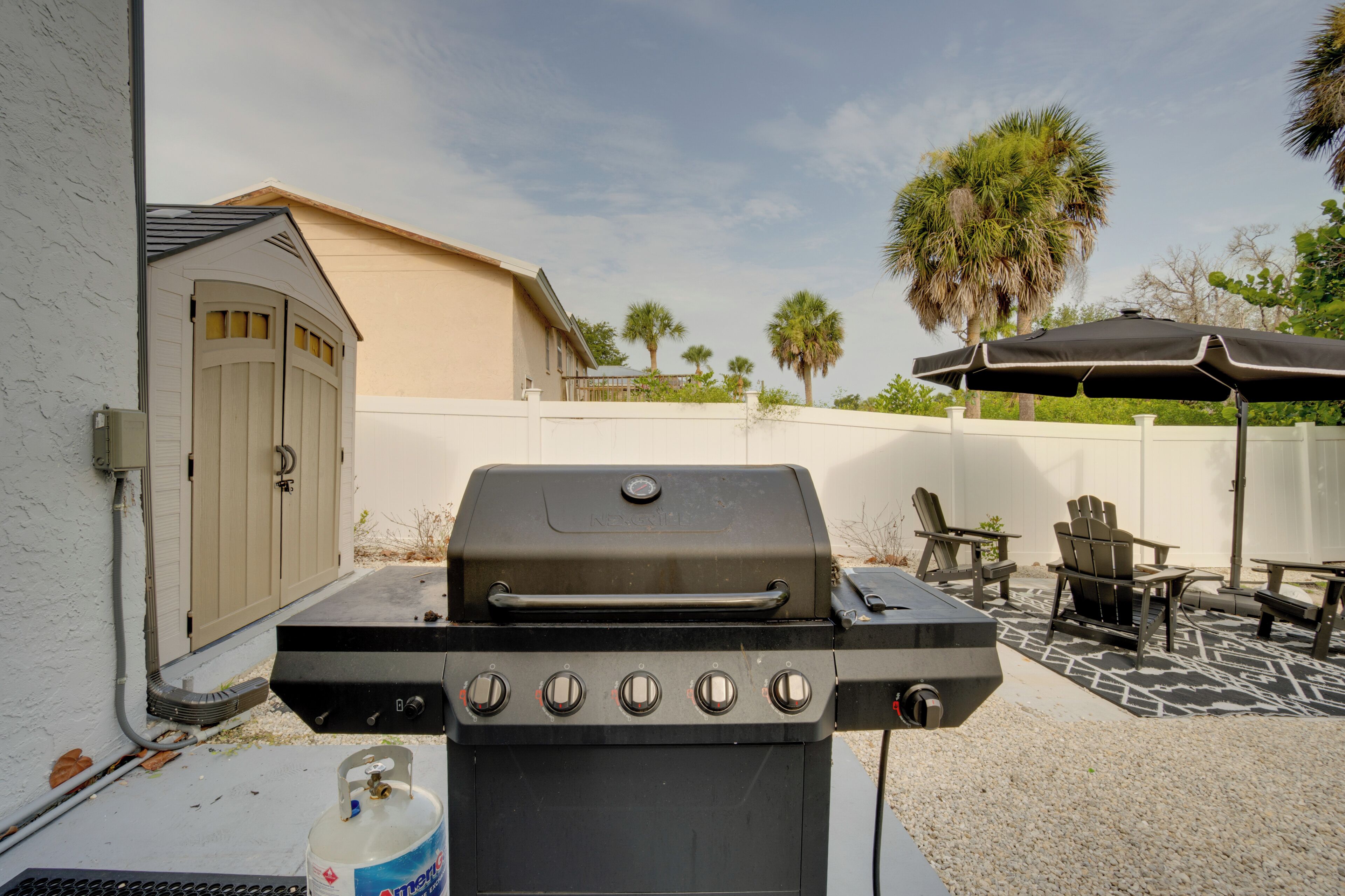 A barbecue grill with multiple burners, a gas tank, and a control panel.