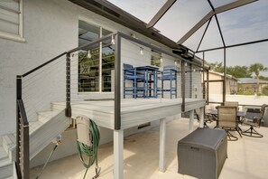 A covered outdoor area with a metal railing, a table, and chairs. - Tropical Bayfront Escape w/ Heated Pool & Dock! (Englewood)