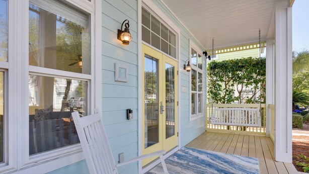 A porch with a white bench, a yellow door, and a blue and white patterned rug. - Breathtaking Santa Rosa Beach Home < 1 Mi to Gulf! (Santa Rosa Beach)