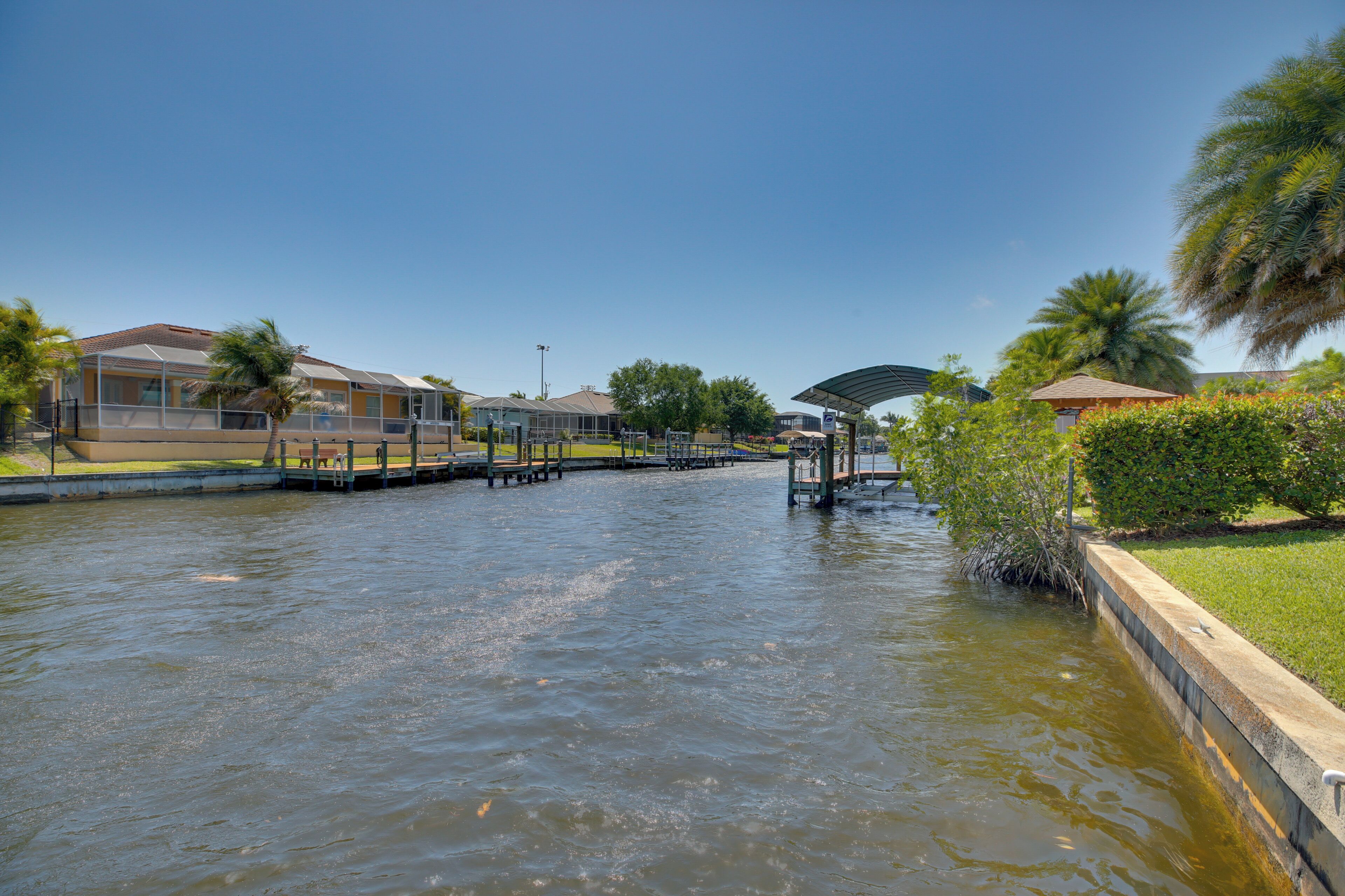 A canal with a bridge, a covered walkway, and buildings along the water's edge.