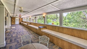 A train car with wooden benches along the windows, a patterned carpet, and a ceiling with a grid pattern. - Bright Steinhatchee Home: Proximity to Ocean! (Steinhatchee)