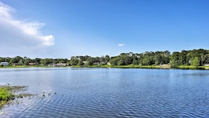 A calm lake with a clear sky, surrounded by greenery and buildings in the distance. - Lake Marion Apt w/ Canoe in Altamonte Springs! (Altamonte Springs)