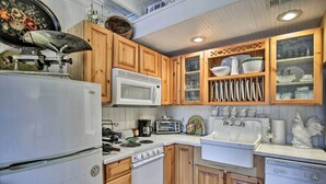 A kitchen with wooden cabinets, a white refrigerator, a microwave, a stove, a sink, and a dishwasher. - Lake Marion Apt w/ Canoe in Altamonte Springs! (Altamonte Springs)