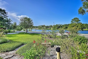 A well-maintained garden with a stone pathway, a bench, and a variety of plants and flowers.