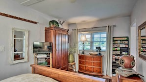 A bedroom with a wooden bed, a TV, a dresser, a lamp, and a bookshelf. - Lake Marion Apt w/ Canoe in Altamonte Springs! (Altamonte Springs)