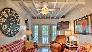 A cozy living room with a large wall clock, a ceiling fan, and a checkered sofa. - Lake Marion Apt w/ Canoe in Altamonte Springs! (Altamonte Springs)
