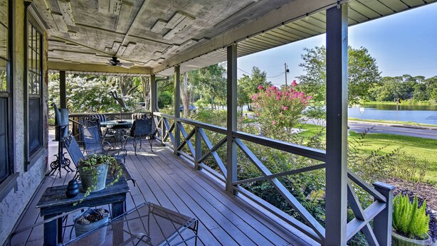 A covered porch with outdoor furniture, a view of a lake, and surrounding greenery. - Lake Marion Apt w/ Canoe in Altamonte Springs! (Altamonte Springs)