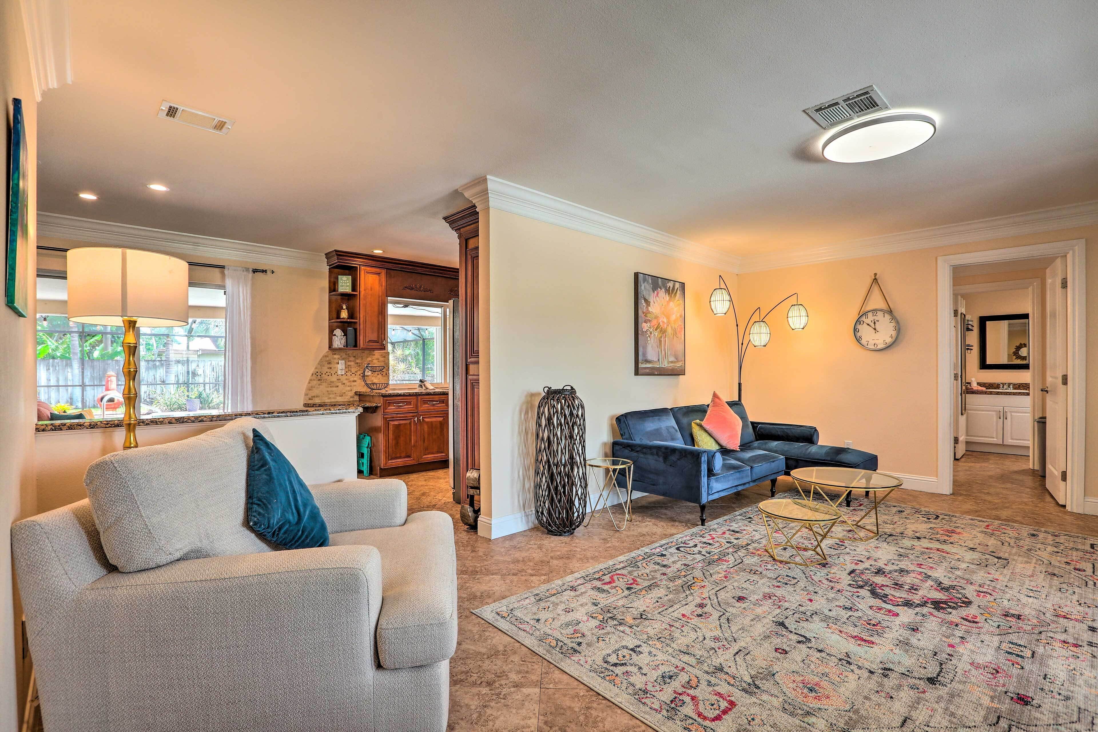 A spacious living room with a large rug, a blue sofa, and a coffee table.