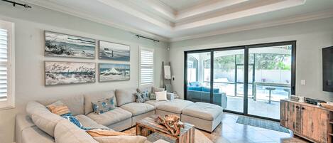 A spacious living room with a sectional sofa, a wooden coffee table, and artwork on the walls.