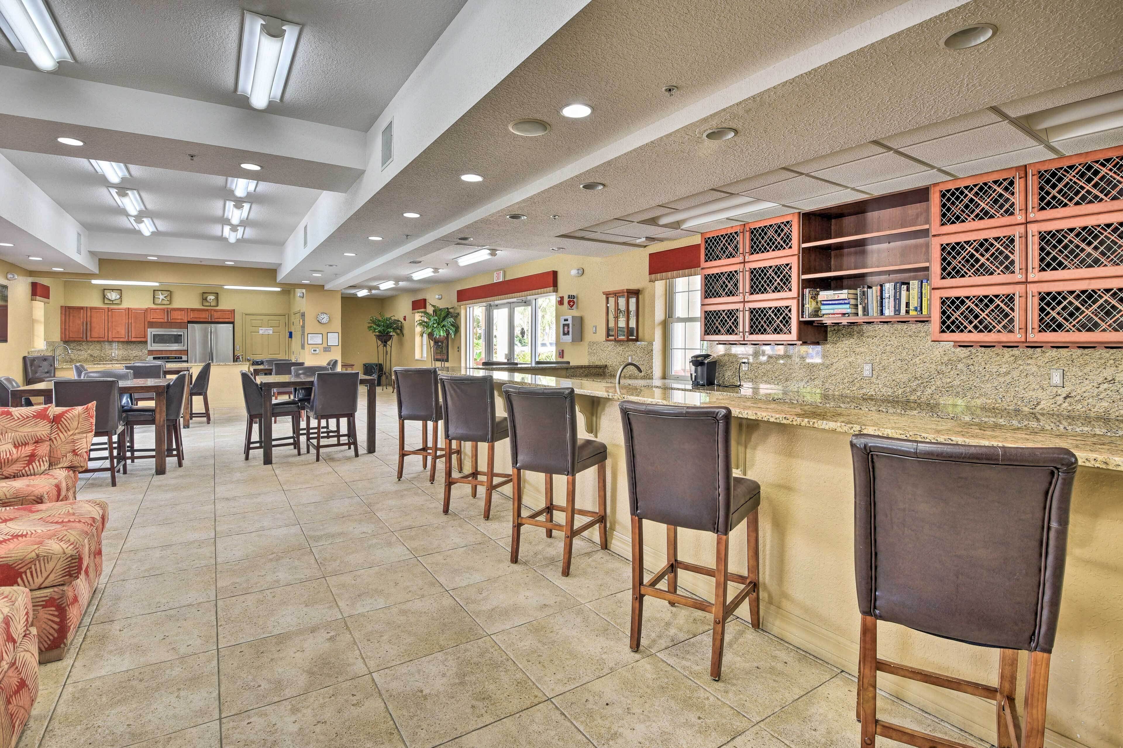 A spacious kitchen area with bar stools, a granite countertop, and wooden cabinets.