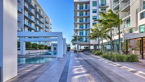 A modern hotel with a swimming pool, outdoor seating, and palm trees. - Chic Miami Condo w/ Pool, 6 Mi to South Beach (Miami)