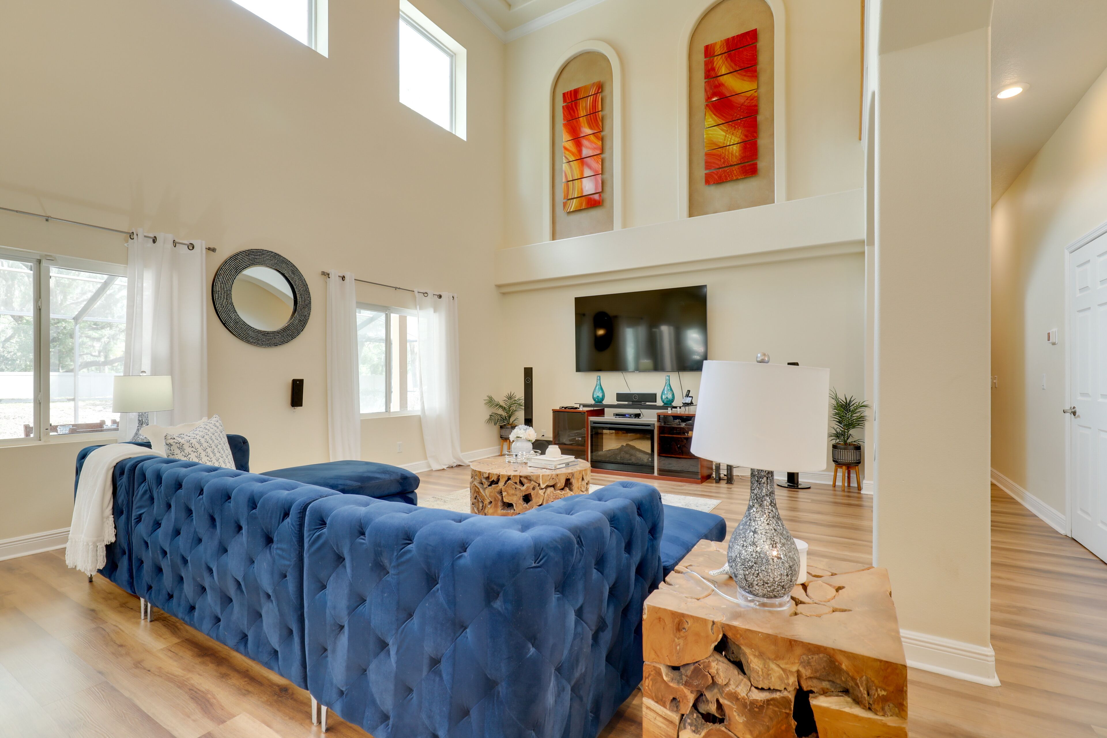 Un salón amplio con un gran sofá azul, una mesa de centro de madera y una chimenea.