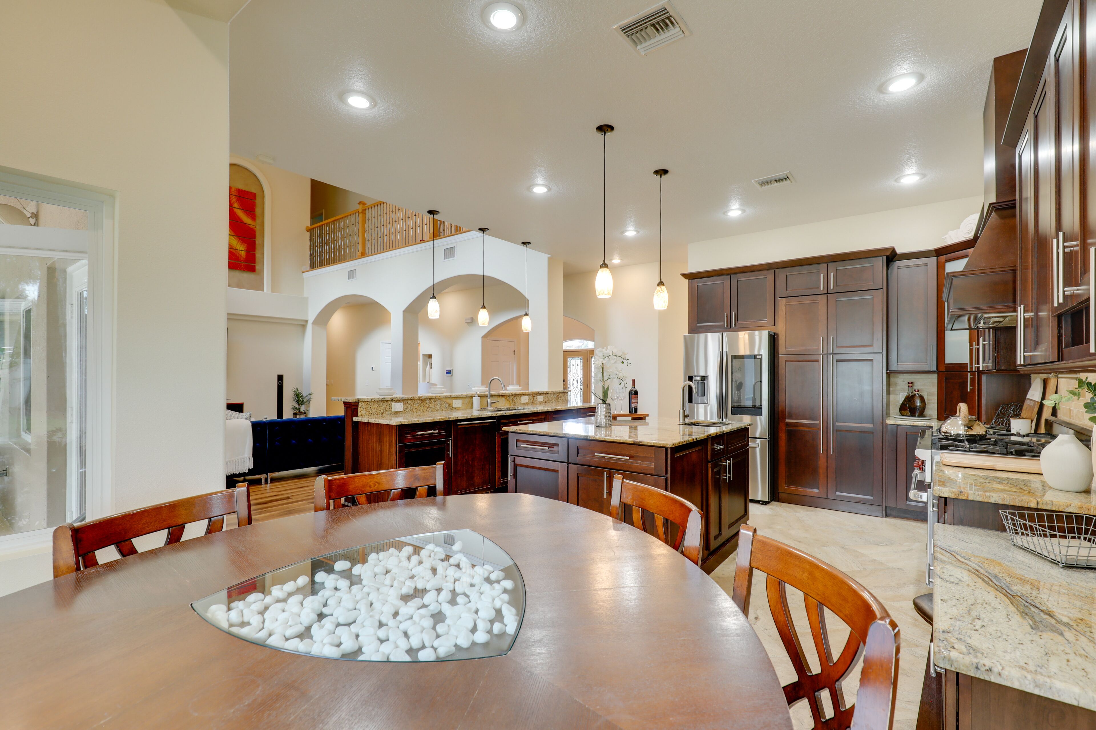 A spacious kitchen with modern appliances, a dining area with a large table, and a cozy seating arrangement.