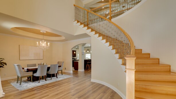 A spacious dining area with a wooden staircase leading to an upper level. - Contemporary Brandon Home w/ Pool & Game Room (Brandon)