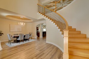 A spacious dining area with a wooden staircase leading to an upper level. - Contemporary Brandon Home w/ Pool & Game Room (Brandon)