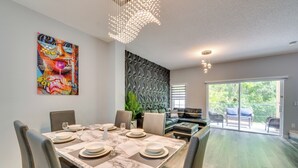 A dining area with a marble table, leather chairs, and a colorful abstract painting on the wall. - Chic Florida Retreat ~ 7 Mi to Walt Disney World! (Kissimmee)