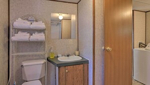 Un baño con inodoro, lavabo, espejo y toallero.