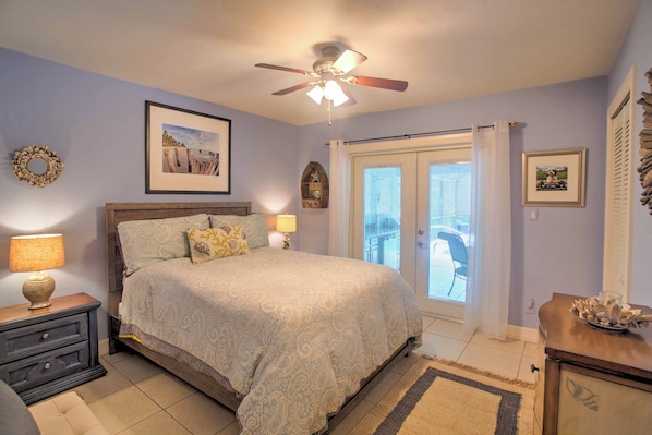 A bedroom with a bed, bedside lamps, a ceiling fan, and a view through a sliding door. - 1 Mi to Beach Access: Naples Home w/ Lanai (Naples)