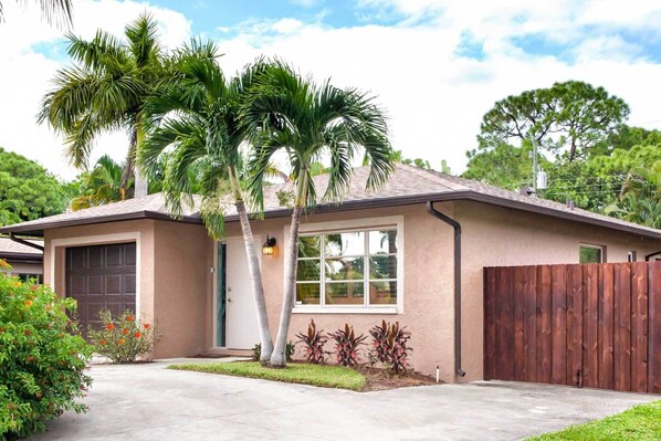 A single-story house with a garage, a wooden fence, and a well-maintained lawn.