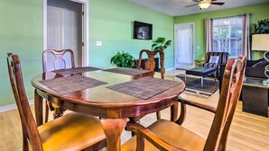 A dining area with a round table, wooden chairs, and a ceiling fan. - Cute Pensacola Townhome ~ 9 Mi to Downtown! (Pensacola)
